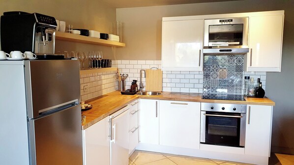 A modern kitchen with stainless steel appliances, white cabinetry, and a wooden countertop. - Apartment 2 pers Residence PISCINE Mandelieu La Napoule Beaches 15mn walk (Mandelieu-la-Napoule)