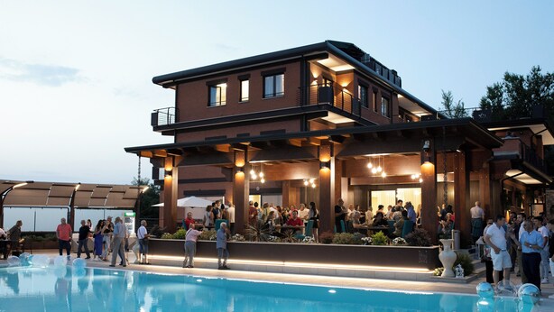 A modern hotel with a pool, outdoor seating, and a covered patio area. - Lual Bleisure Hotel  (Pofi)