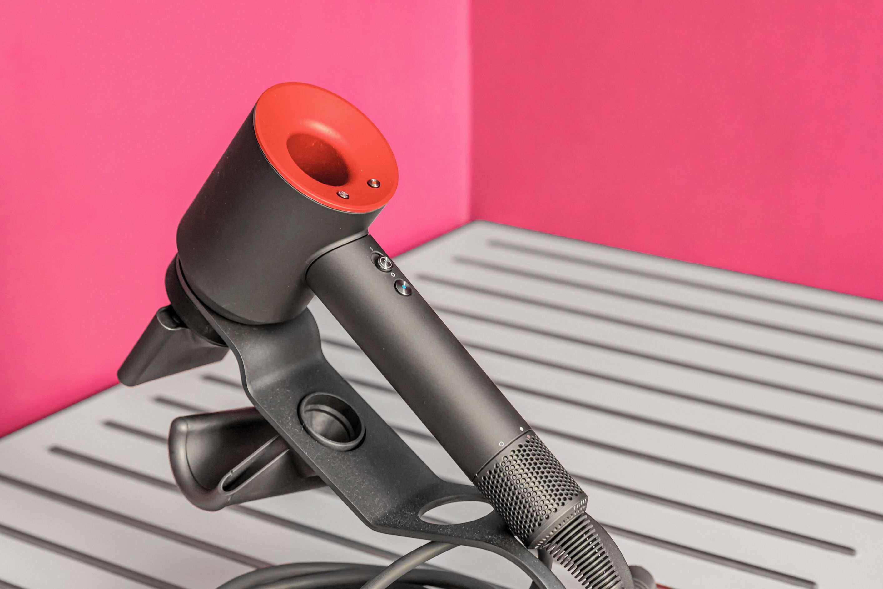A microphone with a red top, mounted on a stand with a metallic finish.