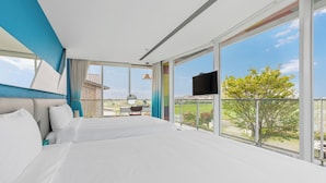 A modern hotel room with a large bed, a TV, and a balcony with a view of the outdoors. - BoxDuoDuo (Wujie)