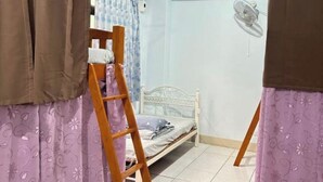 Una habitación con una cama, una escalera y cortinas.