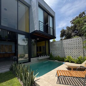 A modern two-story house with a swimming pool, outdoor seating, and a decorative fence. - HOP MANGO exclusiva casa de campo (Ica)
