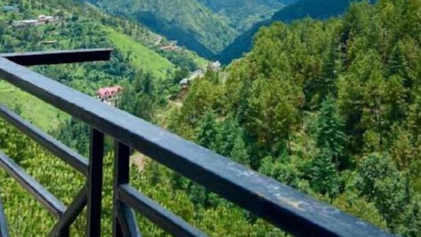 A mountainous landscape with a view of a valley and a distant building. - Uno Prime shimla (Shimla)