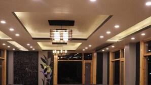 A restaurant with a checkered floor, wooden tables, and cushioned seating. - Uno Prime shimla (Shimla)