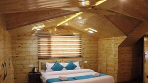 A wooden cabin room with a bed, a nightstand, and a window with blinds. - Uno Prime shimla (Shimla)