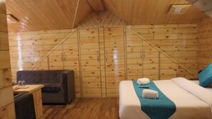 A wooden cabin room with a bed, a sofa, and a small table. - Uno Prime shimla (Shimla)