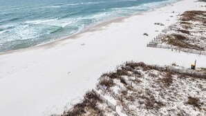A beach with a sandy shore and a wooden fence. - Beautiful Views Easy Beach & Bay Access (Gulf Shores)