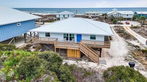 A coastal building with a blue exterior, wooden deck, and a staircase leading to a door. - Beautiful Views Easy Beach & Bay Access (Gulf Shores)
