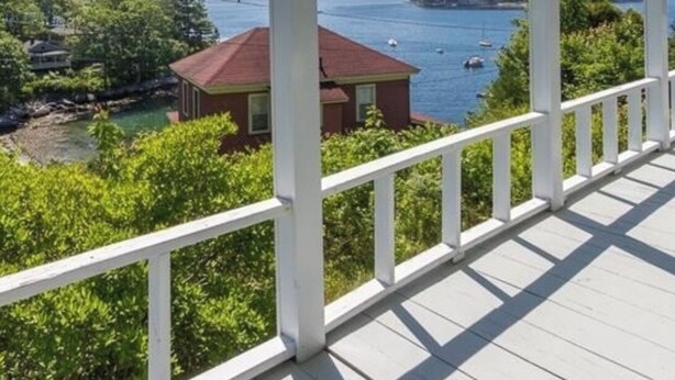 A covered porch with a view of a body of water, greenery, and a distant island. - Ocean views, private beach, garden patio, red clay tennis, dock access, WiFi (Boothbay Harbor)