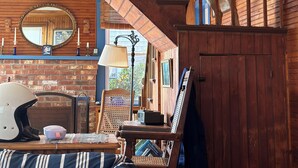 A cozy room with a wooden staircase, a fireplace, and a dog on the stairs. - Ocean views, private beach, garden patio, red clay tennis, dock access, WiFi (Boothbay Harbor)