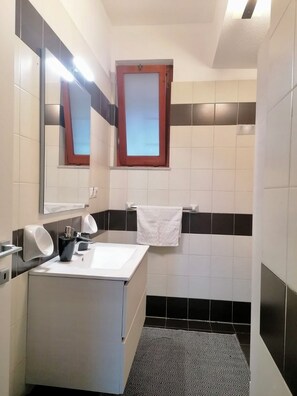 Een douche, een haardroger, een bidet, handdoeken