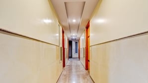 A long, narrow hallway with a polished marble floor and cream-colored walls. - Hotel Lord Krishna Palace  (New Delhi)