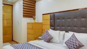 Un dormitorio con una cama, un ventilador de techo, un armario de madera y una ventana con persianas.