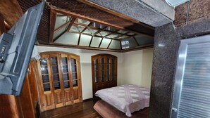 Ein Zimmer mit einem Bett, Holzschränken und einer Decke mit einem Oberlicht.