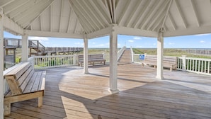 A covered wooden deck with benches and a view of the beach. - Laguna Sunset Elevator Beach Access (Gulf Shores)