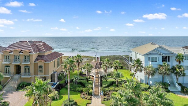 A coastal property with a central pathway, palm trees, and a view of the ocean. - Laguna Sunset Elevator Beach Access (Gulf Shores)