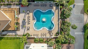An aerial view of a resort with a central swimming pool, lounge areas, and well-maintained landscaping. - Laguna Sunset Elevator Beach Access (Gulf Shores)