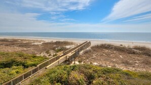 Une plage avec une promenade en bois qui mène au bord de l’eau.