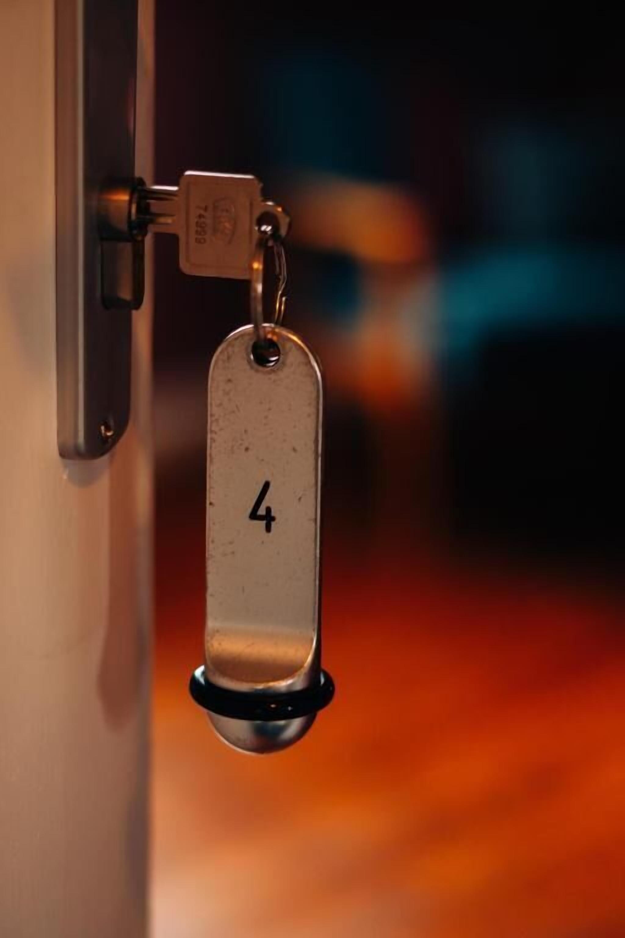 Una puerta con un llavero metálico que tiene el número 4.