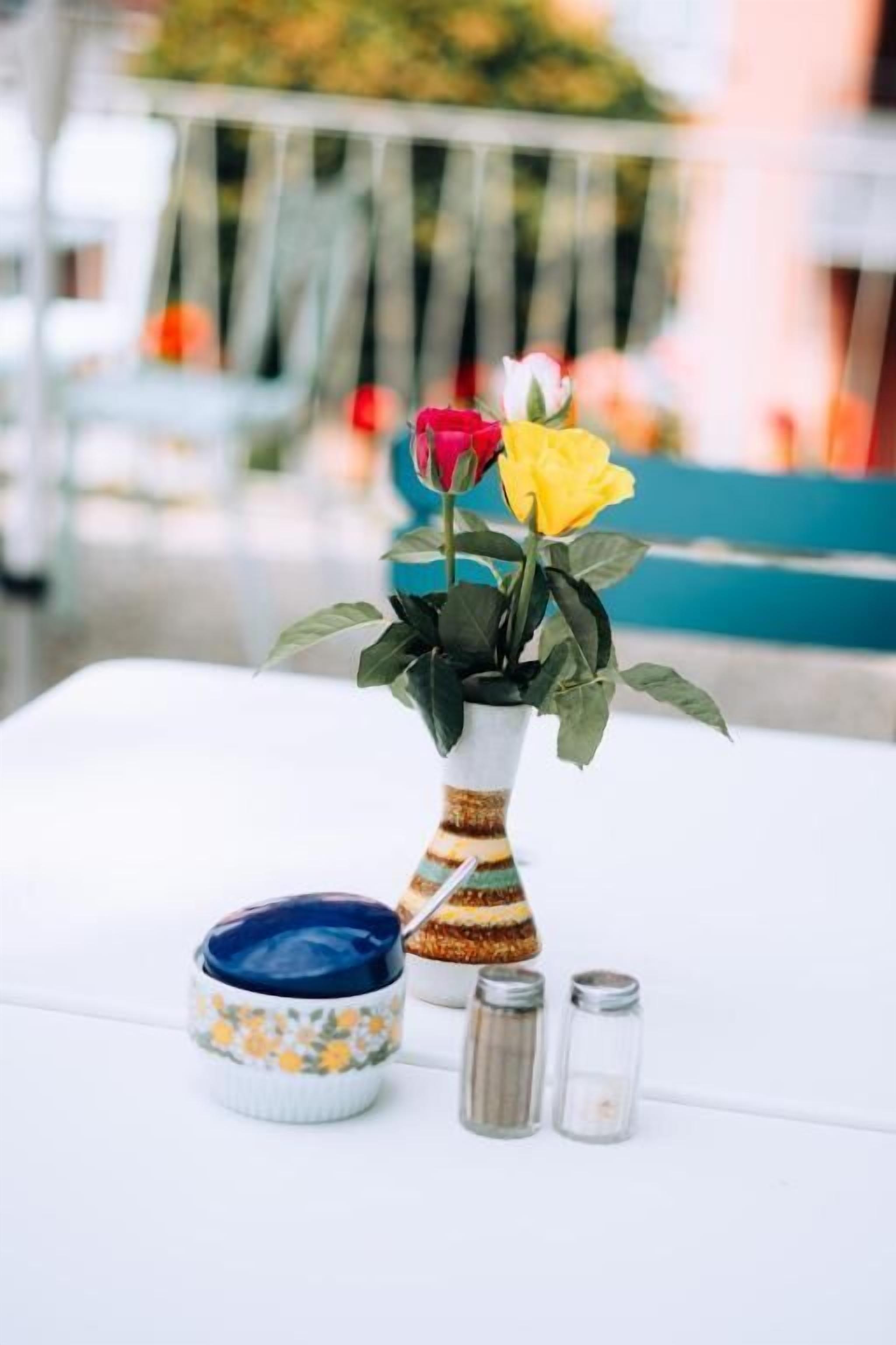 Una mesa con un florero, salero y un tazón decorativo.