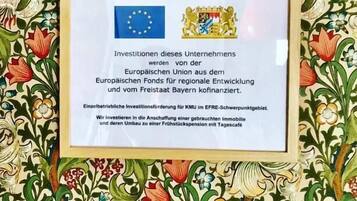 Un certificato incorniciato con la bandiera e lo stemma dell'Unione Europea, che attesta il sostegno agli investimenti per un'azienda nell'area EFRE-Swiftpointgebiet.