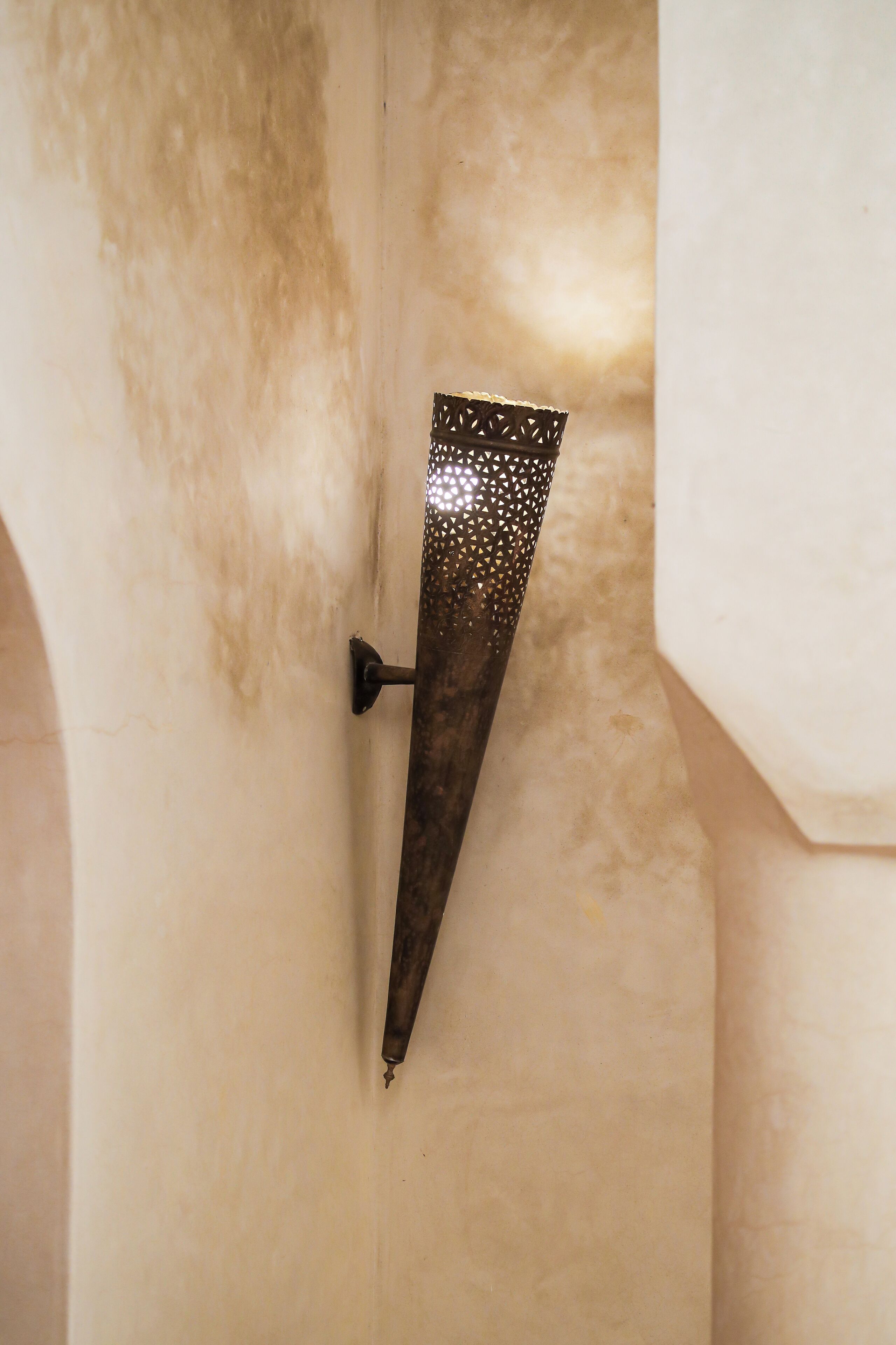 A metal fixture attached to a wall with a textured surface.