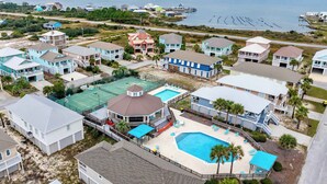 A coastal residential area with houses, a tennis court, and a swimming pool. - Short Walk to Beach Hot Tub Cold Plunge Pool (Gulf Shores)