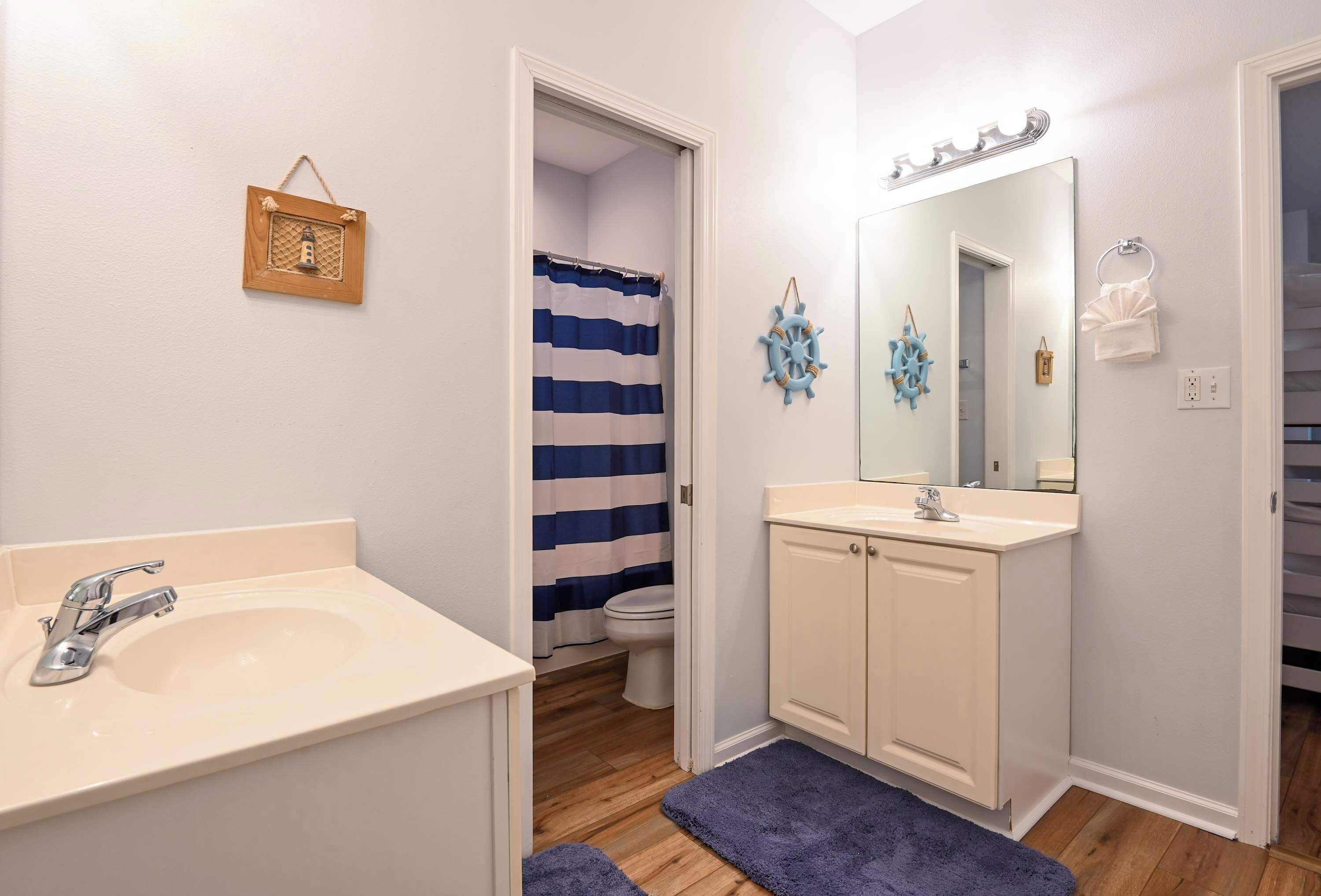Ein Badezimmer mit Waschbecken, Spiegel und Toilette.