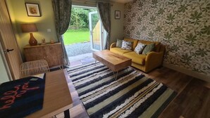 A cozy living room with a sofa, a coffee table, and a patterned rug.