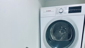 En kombinerad tvätt- och torkmaskin där maskinerna är placerade ovanpå varandra, med en kontrollpanel och ett handtag.