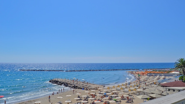 A beach with umbrellas and sun loungers, a pier, and a clear blue sky. - 2 bedroom cozy apartment in Sanremo (Sanremo)