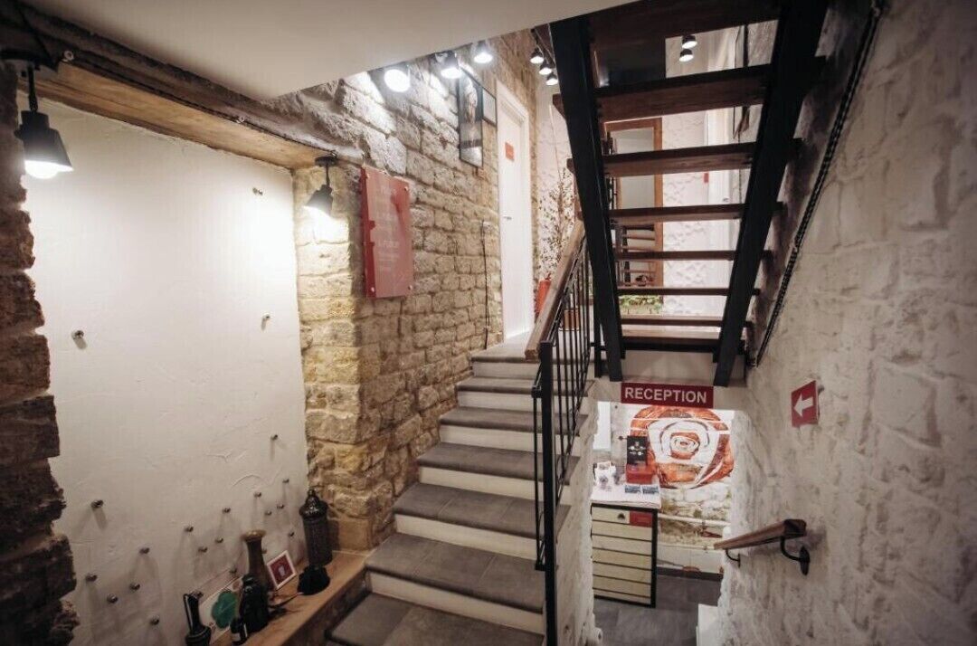 Eine Treppe mit Empfangsschild, Steinwänden und einem Holnändergeländer.