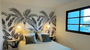 A bedroom with a bed, two bedside tables, a window, and a wall mural. - Gîte Luna villa 6 persons with jacuzzi, children's playground and petanque area (Chaumont-sur-Loire)