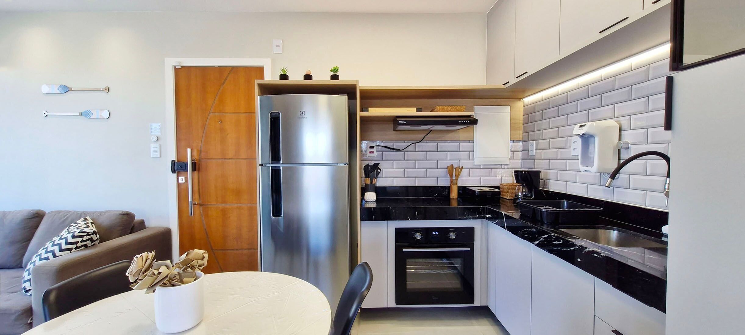 A compact kitchen with a built-in refrigerator, oven, and black countertop.