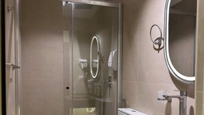 A modern bathroom with a glass-enclosed shower, a marble sink, and a large mirror. - Imperial Hotel (Cairo)
