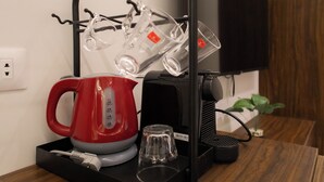 A modern kitchen area with a coffee maker, kettle, and glassware holder on a wooden countertop. - Imperial Hotel (Cairo)