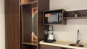 A compact kitchen with a built-in microwave, a coffee maker, and a small refrigerator. - Imperial Hotel (Cairo)