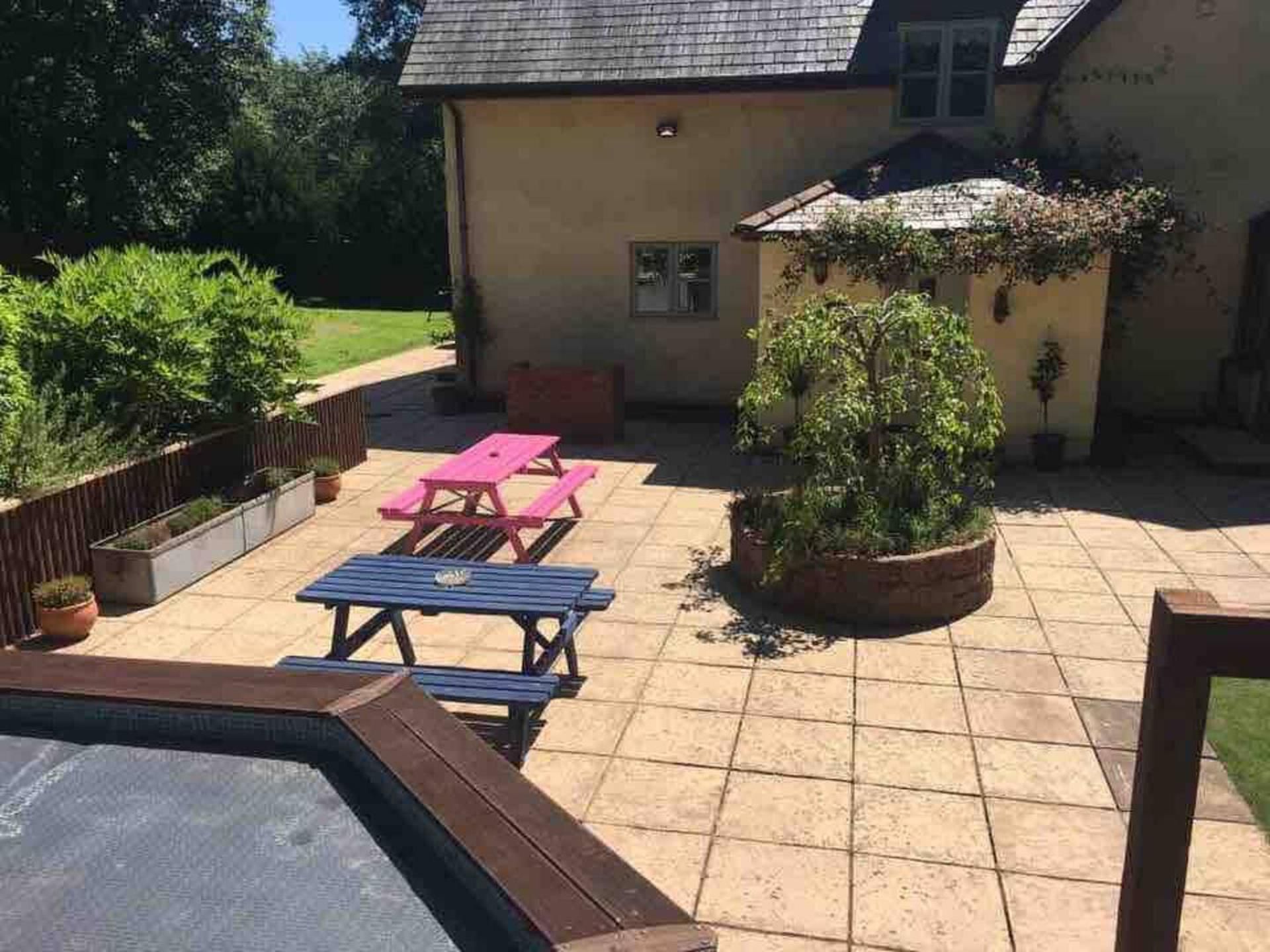 A patio area with picnic tables and potted plants.