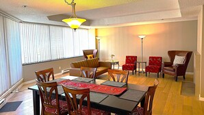A dining area with a table set for four, surrounded by chairs with patterned cushions. - Spacious and comfortable newly updated penthouse condo in downtown Vancouver (Vancouver)
