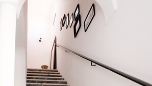 A staircase with a handrail and a wall with framed pictures. - 2-BR House with garden in fishing village Ferragudo, by the river and the ocean. (Ferragudo)