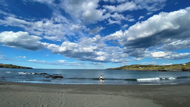 A beach with a clear sky and waves.