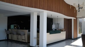 A modern hotel lobby with a reception desk, seating area, and a bar. - UNICO Boutique Hotel (Hochheim am Main)
