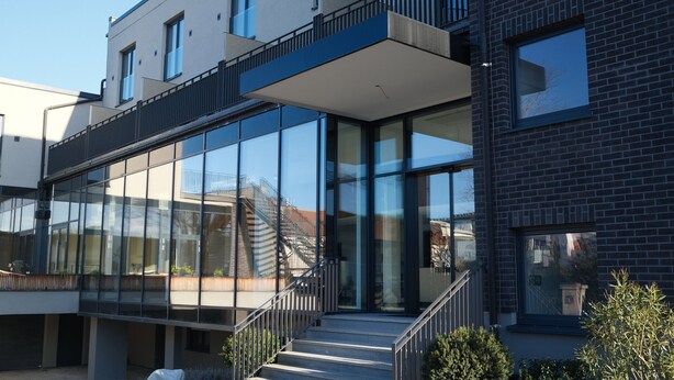 A modern building with large glass windows, a staircase, and a flat roof. - UNICO Boutique Hotel (Hochheim am Main)