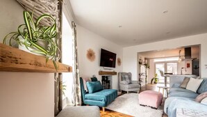 Un salon moderne avec une cheminée, des sièges confortables et un téléviseur.