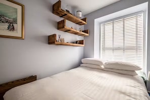 2 habitaciones, escritorio y tabla de planchar con plancha