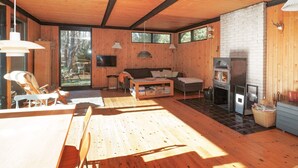 Un intérieur en bois avec une cheminée, un canapé et un téléviseur.