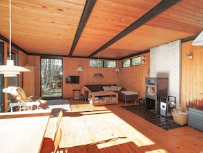 Un intérieur en bois avec une cheminée, un canapé et un téléviseur.