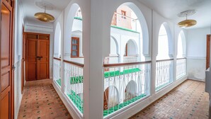 A corridor with arched ceilings, a tiled floor, and a balcony with a railing. - Riad Ilyan & Spa  (Marrakech)