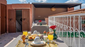 A breakfast setup with a table, breakfast items, and a view of the sky. - Riad Ilyan & Spa  (Marrakech)