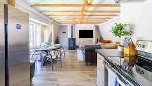 Una cocina moderna con vigas de madera, una isla central y una estufa integrada.